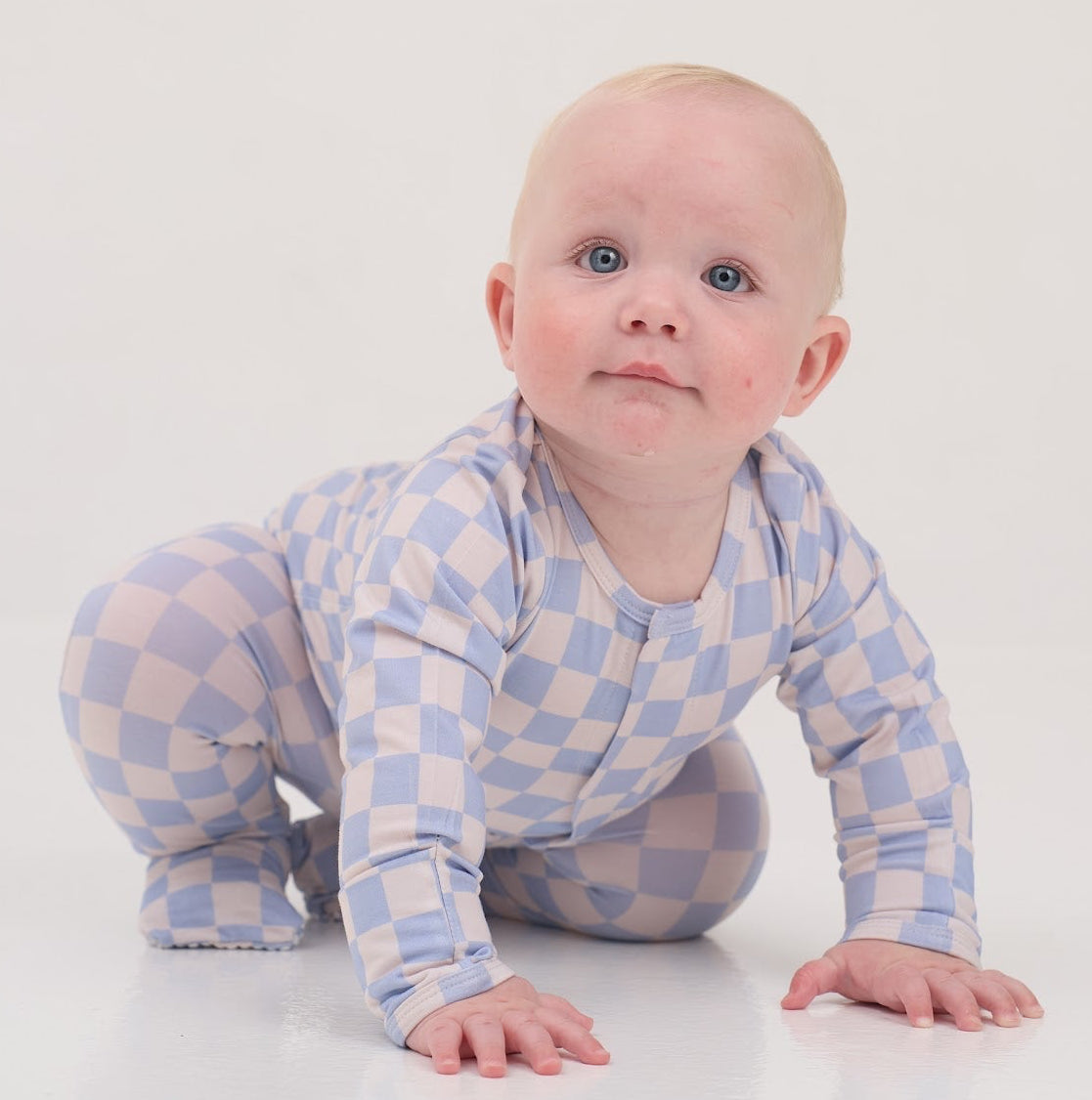 Baby in a checkered outfit on a white background