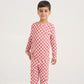 Child wearing a red and white checkered pajama set on a white background