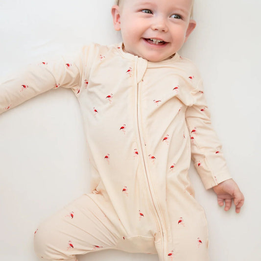 Baby wearing a flamingo print onesie with zip
